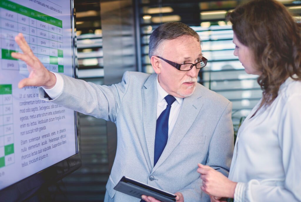 working in different jobs with AI holograms or code overlaying their workspace. Caption: Microsoft’s study identified 40 jobs with high AI disruption potential, but many roles will evolve rather than disappear.